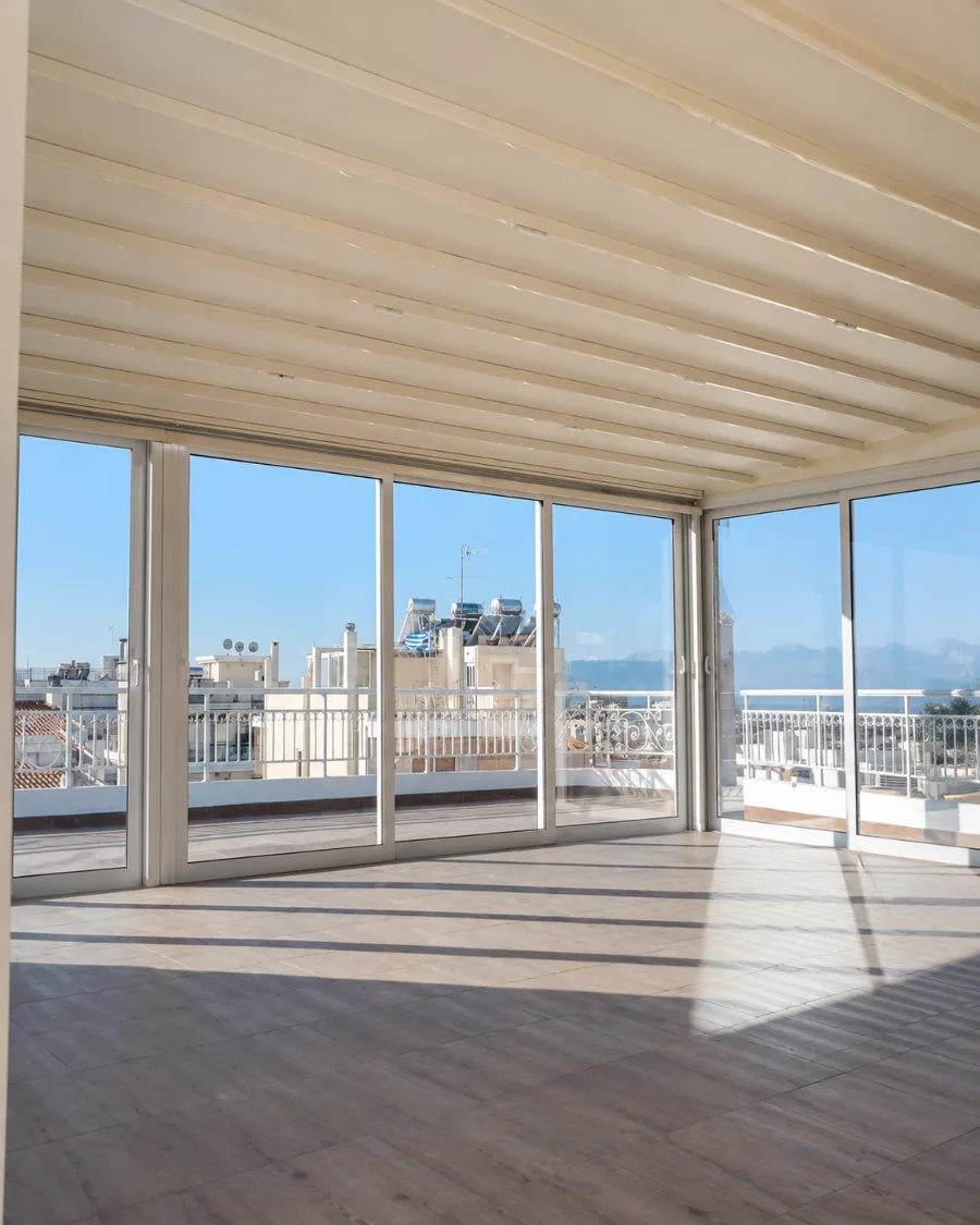 Glazed roof terrace with sliding glass elements and a view over the city