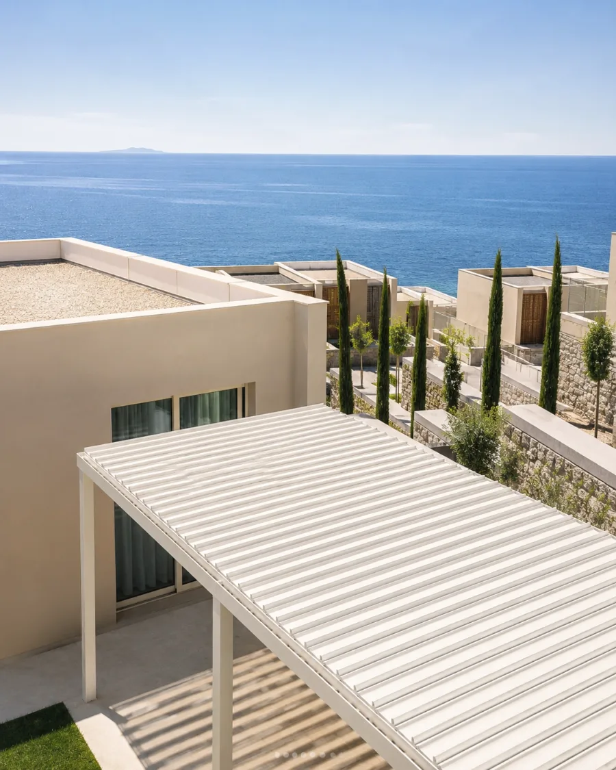 White louvre roof above the terrace of a holiday residence with a view of the sea